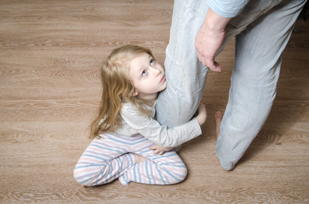 Kislány szorytja az apukája lábát, nem akar elválni; szeparációs szorongás
