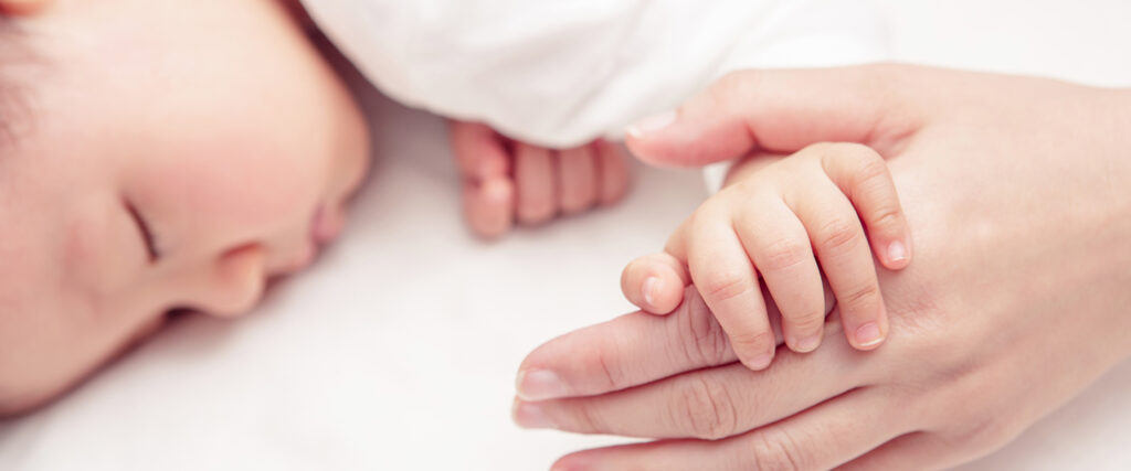Kisbaba megszorítja a mami ujját